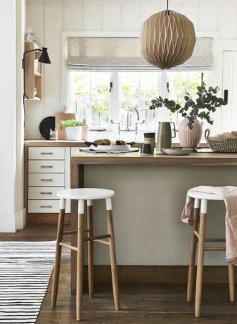 lagom, švédska myšlienka mať správne množstvo, je zachytená v dokonalej rovnováhe neutrálnych odtieňov ružovej farby, dreva a útulných textúr neutrálnej a drevená kuchyňa s kuchynskou linkou, bielou farbou natreté stoličky a čelá zásuviek dodajú tomuto elegantnému drevenému prívesku iba dostatočný kontrast svetlo