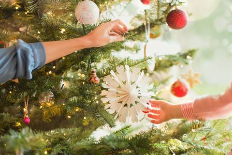 Matka a dcéra visí snehová vločka ornament na vianočný strom