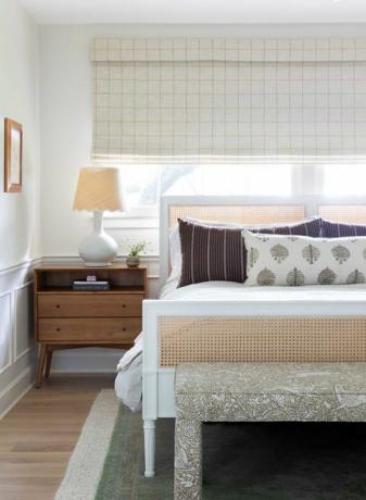 hlavná spálňa, drevený bočný stolík, biely a ratanový rám postele, koberec v zelenej farbe, veniec do koruny