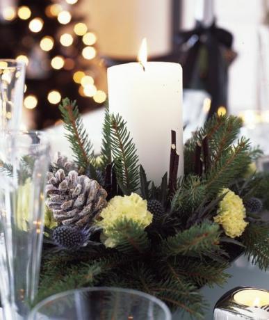 čiernobiele vianočné ozdoby so striebornou a forstovanou fialkou do domácnosti, jedálenský stôl so stredom sviečky vyrobený z čerstvého rezaného konára, šišiek a klinčekov