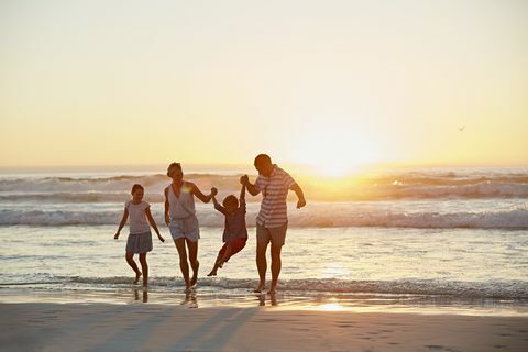 Rodičia s deťmi, ktorí si užívajú dovolenku na pláži