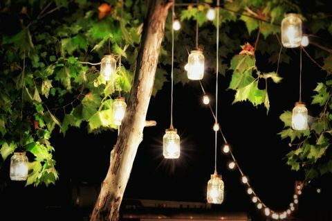 Osvetlené ozdoby visí zo stromu v záhrade v noci