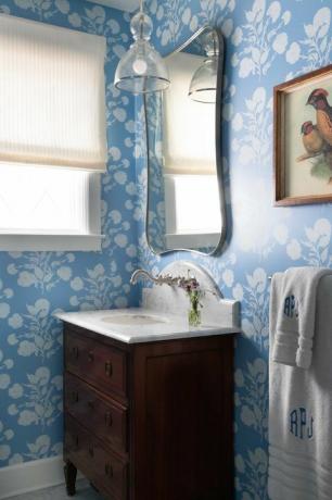 prášková miestnosť, modrobiele tapety, hnedá komoda ako márnosť s mramorovou doskou, monogramované uteráky