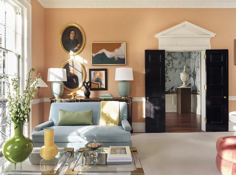 obývacia izba, oranžové tapety, čierne dvere, modrý gauč, žltá a zelená váza