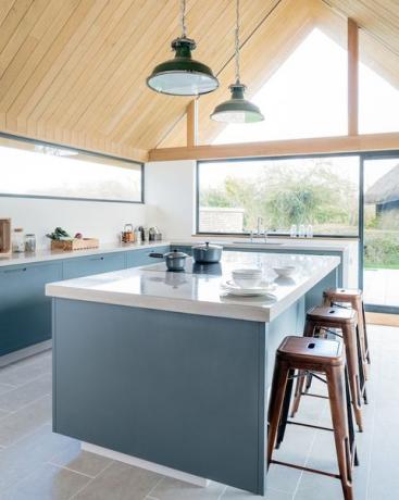 Modrá kuchyňa s raňajkovým barom a drevenou strechou