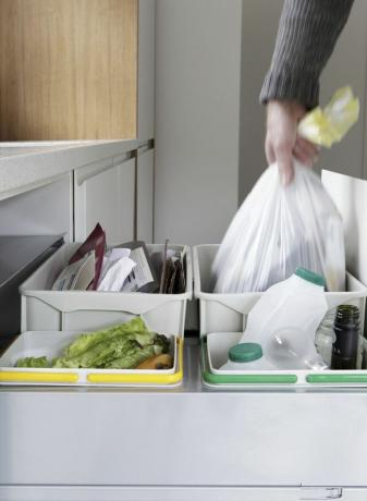 Osoba, ktorá odstraňuje vrece na odpad z odpadovej a recyklačnej zásuvky