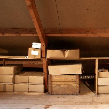 starý drevený podkrovný interiér so starými kartónovými krabicami na skladovanie alebo sťahovanie, zblízka