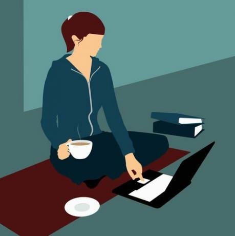 Žena sediaca na podlahe s šálkou čaju a pomocou prenosného počítača