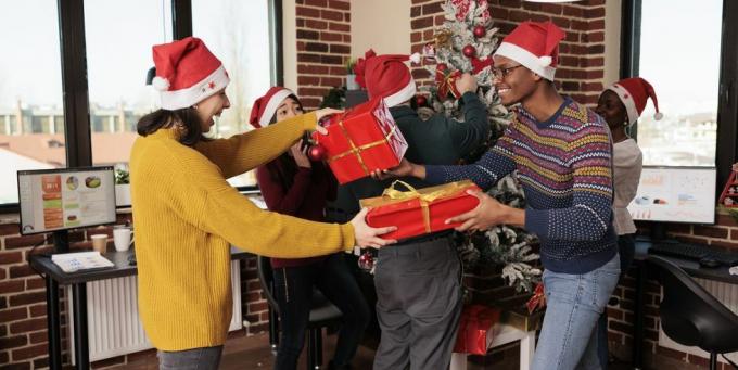 rôznorodá skupina spolupracovníkov, ktorí si vymieňajú sviatočné darčeky