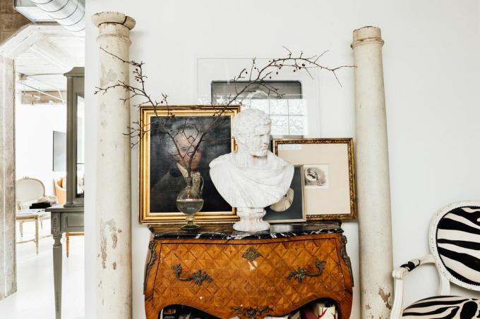 starožitný konzolový stolík s orámovaným umením a postavami na ňom
